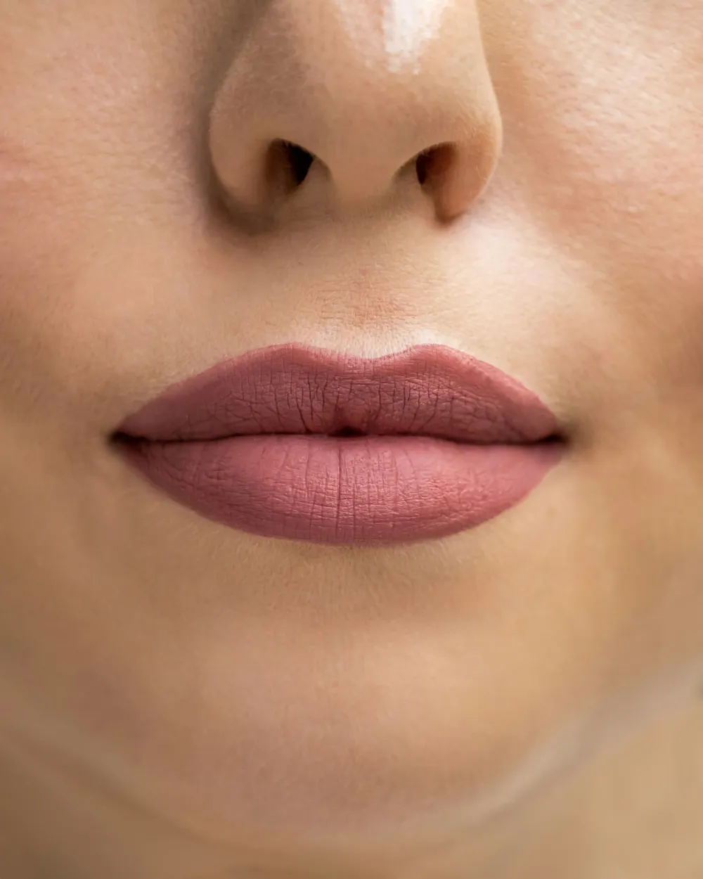 Symmetrical lips with a balanced upper and lower lip in a soft mauve tone
