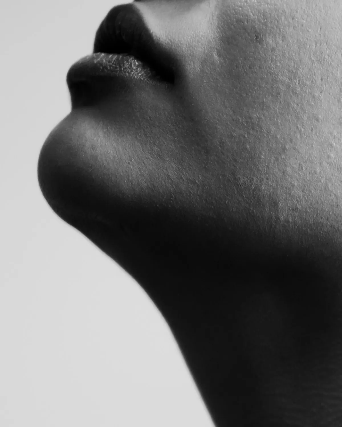 Black-and-white side profile of soft, full lips and a defined chin and jawline
